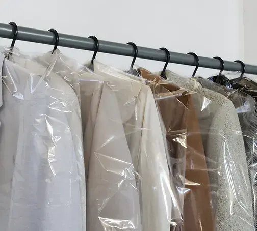 A row of cleaned shirts, blouses and jackets on the rack