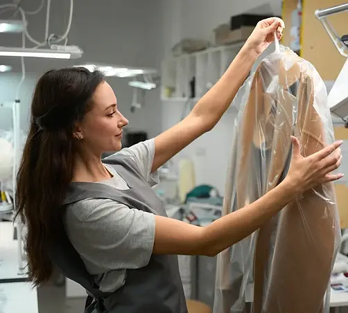 A CleanMeNow team member inspecting a garment before cleaning in Draper, Utah
