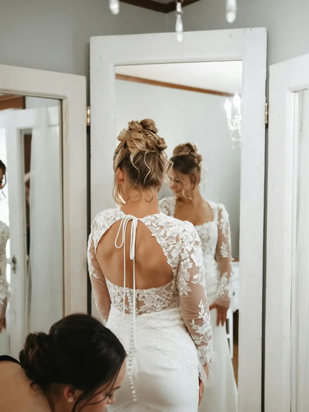 A bride seeing the back of her altered gown in the mirror